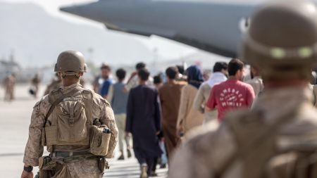 U.S. Marines guide evacuees on to a U.S. Air Force pIane during an evacuation at Hamid Karzai International Airport in Kabul, Afghanistan, on August 21, 2021. (Photo via U.S. Marines on Twitter)