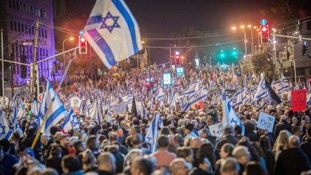 Crowds of protesters wave flags during a demonstration against the proposed judicial reforms in Tel Aviv on January 21, 2023. (Photo by Eyal Warshavsky/SOPA Images/LightRocket via Getty Images)