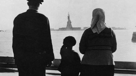 An immigrant family looking at the Statue of Liberty from Ellis Island, circa 1930. (Photo by FPG/Getty Images)