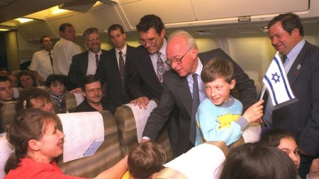 Former Prime Minister Yitzhak Rabin shakes hands with new Russian immigrants on their flight from Russia to Israel, on April 27, 1994. (Photo: Avi Ohayon)
