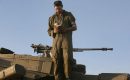 An Israeli soldier wearing Tefilin, conducts morning prayers on top of a tank. (MENAHEM KAHANA/AFP via Getty Images)