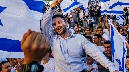 Bezalel Smotrich is hoisted up by Israelis as they dance and wave the national flag rally outside the Old City’s Damascus gate for the annual flag march in Jerusalem on June 15, 2021. (Photo: Marcus Yam/Los Angeles Times)